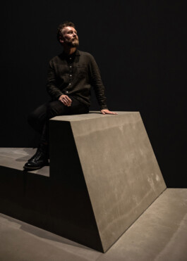 Ivo Jelinek, founder of IJarchitecture, seated on a custom-designed bench at NXT Museum in Amsterdam for the Life in Different Resolution exhibition by Random International. 
