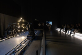 Visitors at NXT Museum observing '15 Points' installation by Random International, with a minimalist set design by IJarchitecture dividing the performance and audience spaces.