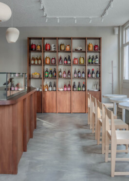Interior of Saint-Jean Deli in Amsterdam, featuring minimalist wooden furniture and a color palette inspired by Scandinavian aesthetics. The bakery is designed by architect Ivo Jelinek from Amsterdam based studio IJarchitecture. 