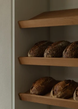 Bread display with wooden shelves at Saint-Jean Deli in Amsterdam, designed by IJarchitecture.